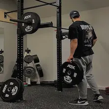Home gym set up pour entraînements de musculation à la maison avec rack à squat mural et plaques de poids ATX