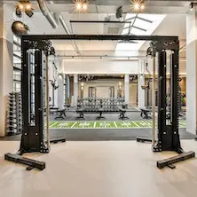 Salle d'entraînement physique commerciale avec équipements multiples dont câble crossover ATX